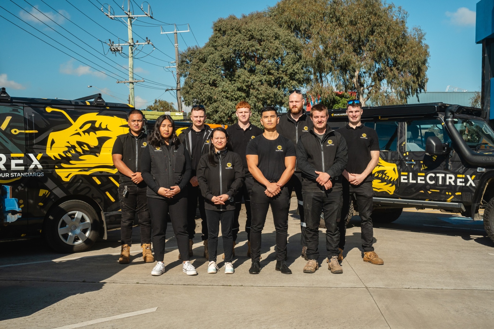 The Electrex Melbourne team standing in front of branded service vans